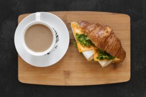 coffee with sandwich on wooden tray