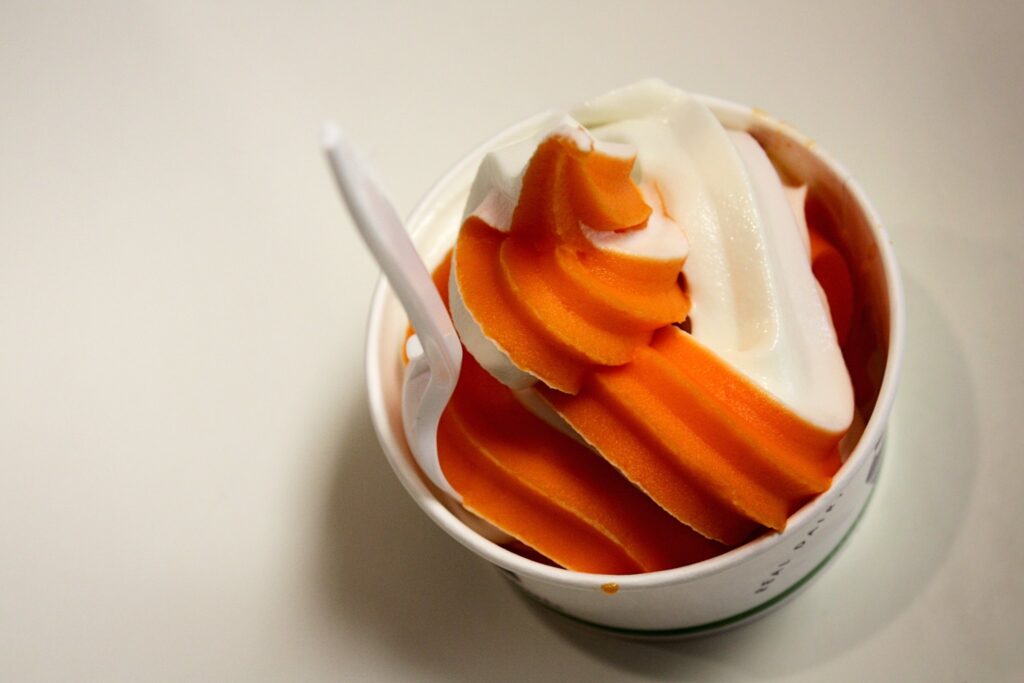 orange and vanilla swirl ice cream in a cup