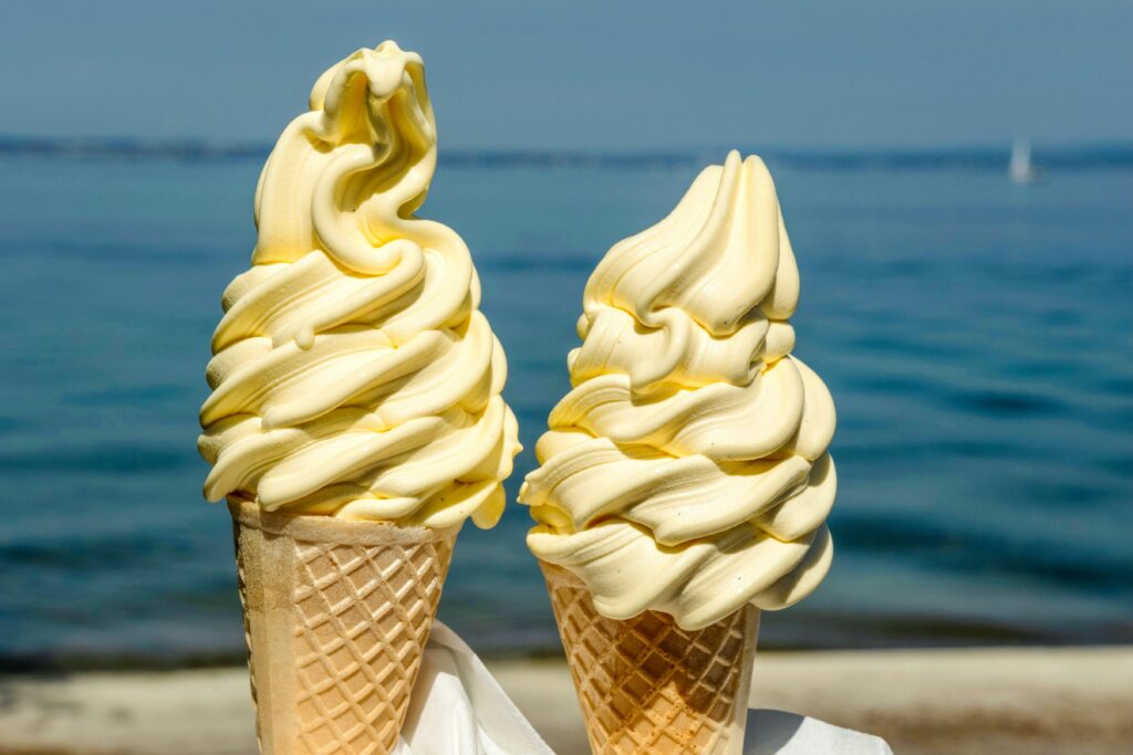 two yellow soft serve ice cream in cones